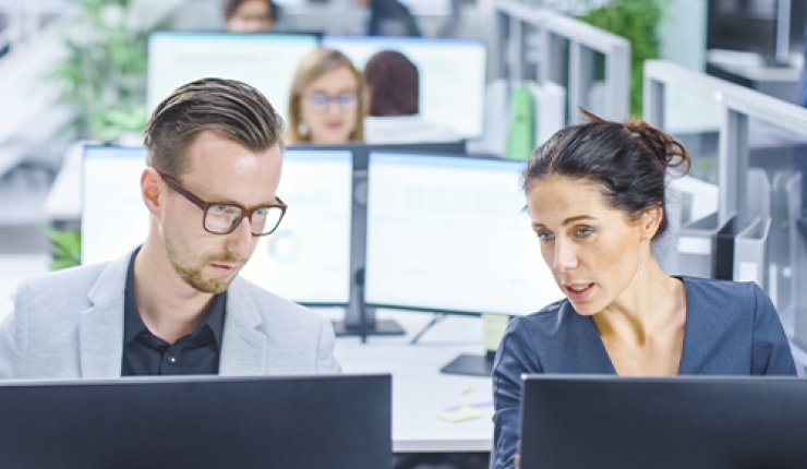 two people in front of desktops