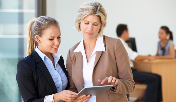 two people viewing a tablet device